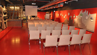 Roter Seminarraum mit Sthlen und Leinwand